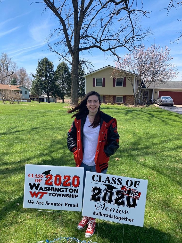 Washington Township High School student stands behind senior class signs