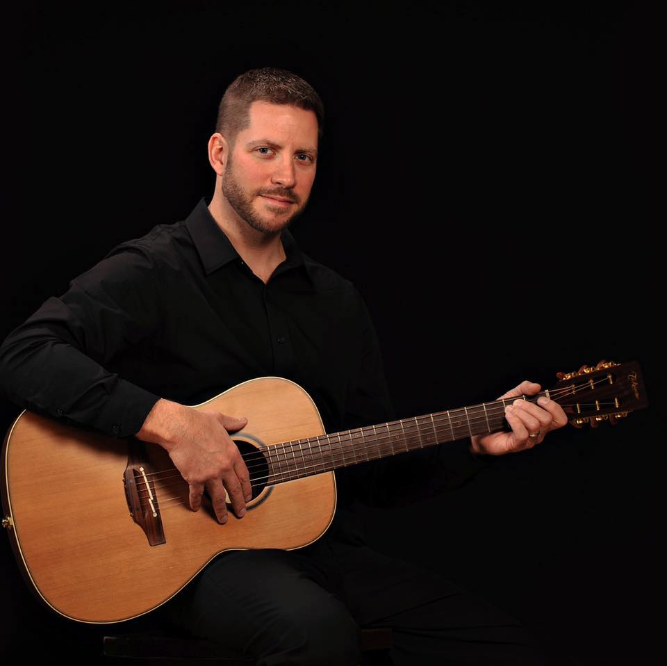 Angelo Cicco plays acoustic guitar