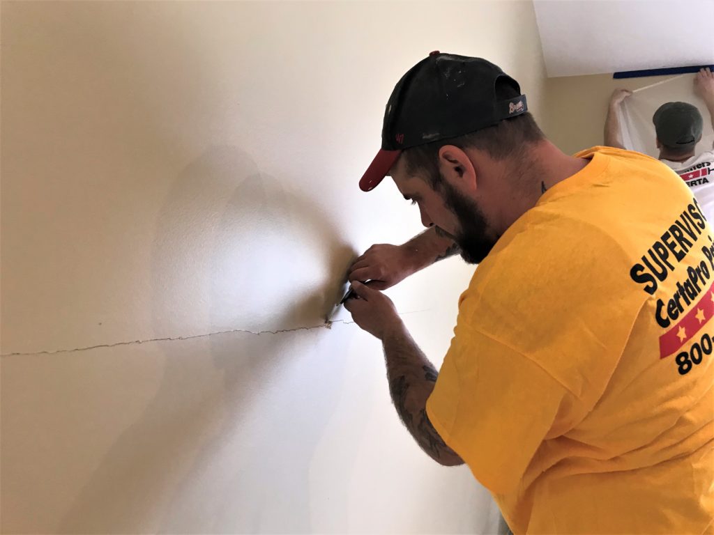 Professional painter patching wall