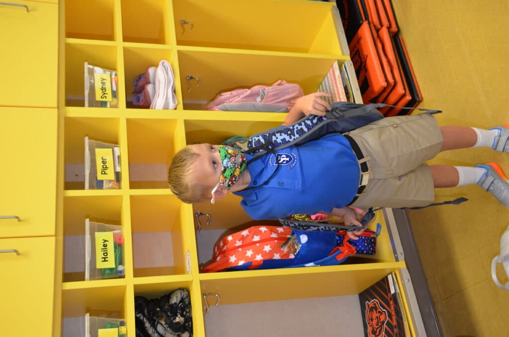 boy taking off backpack